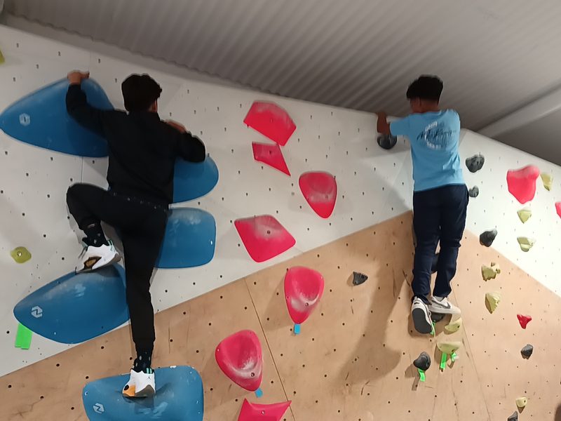 Dos alumnos subiendo por el muro de bloque