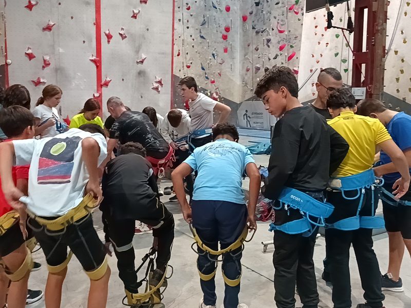 Alumnado colocándose el arnés antes de escalar
